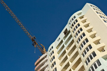 Fototapeta na wymiar Construction site of apartment building with crane machinery against clear blue sky. Kharkov, Ukraine