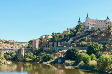 Fototapeta na wymiar view from the river bank on the fortress wall and castles of the ancient Spanish city of Toledo