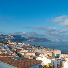 Obraz premium top view of a small spanish town spread out on the seashore and on the slopes of the mountains