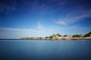 the atmosphere of the beach or the coast before the afternoon with calm waves and sunny weather set against the background of the high seas and mountains or plateaus