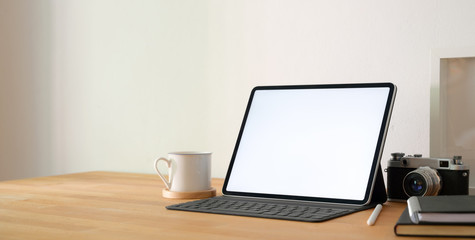 Close-up view of professional photographer workplace with blank screen tablet and office supplies