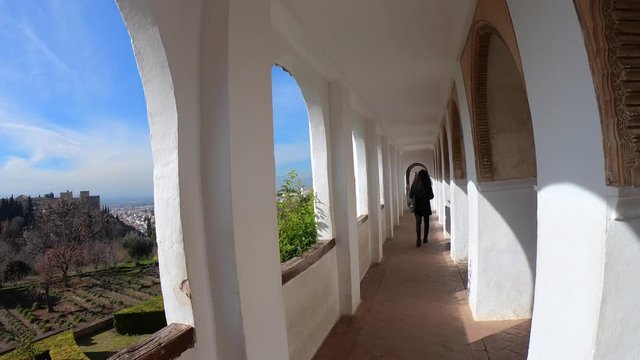  Woman walking through the Generalife gardens in the Alhambra Palace. Granada, Andalusia, Spain.4K shot.
