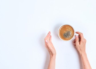 Female hand hold coffee cup on wood table. Top view