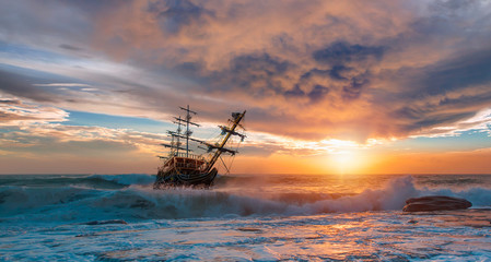 Old ship sailing in front of the sunset 