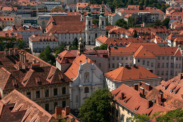 Fototapeta na wymiar Aerial View Of Graz City Center. Church of Trinity, Mariahilfkirche, tiled roofs of city buildings