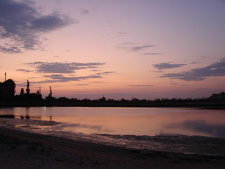 A fantastic variety of colors of the evening sky at sunset reflected on the calm water surface of the gulf.