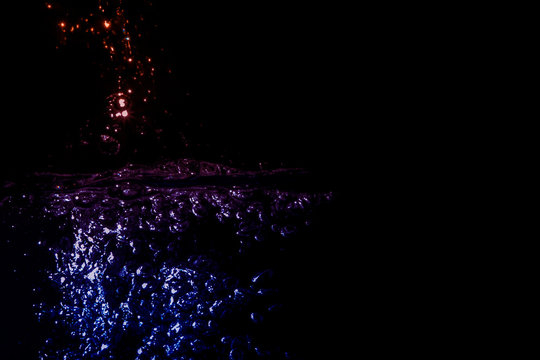 natural black water surface wave background with abstract white bubble reflexing with trendy neon light of dark navy blue