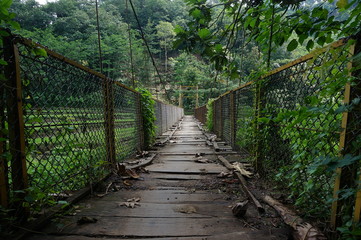 Fototapeta na wymiar a suspension bridge still made of wood and an iron stand was used to cross the river connecting the two villages