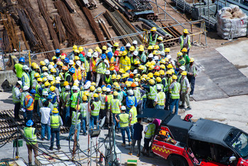 Construction workers wearing helmets at a construction site learning fire fighting skills
