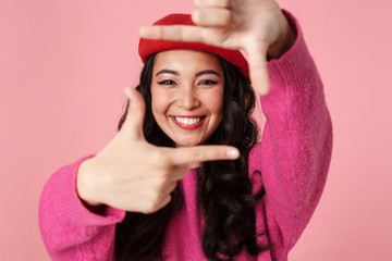 Image of asian girl smiling and showing photo frame with her fingers