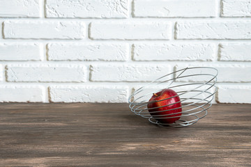 wood table with juicy apple fruit on white brick wall texture background.