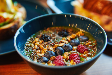 Smoothie with nuts and berries in a bowl, raspberries, blackberries, blackberries, peanuts, grains, vegan food