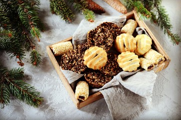 Mix of Christmas cookies in a wooden box on a gray background with Christmas decorations