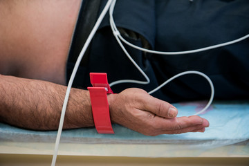 Getting ready. Doctor in white robe getting the patient ready for electrocardiogram