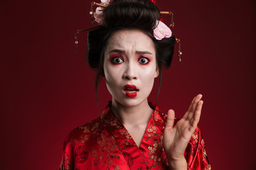 Image of shocked geisha woman in japanese kimono gesturing hand
