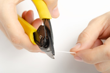 master's hands with optical fiber stripper, closeup optical fiber. Isolated background