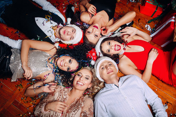 Fototapeta premium Group of friends at club having fun and lying on the floor .New years party