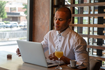 Business People Lifestyle. African American Man Working On Laptop In Cafe
