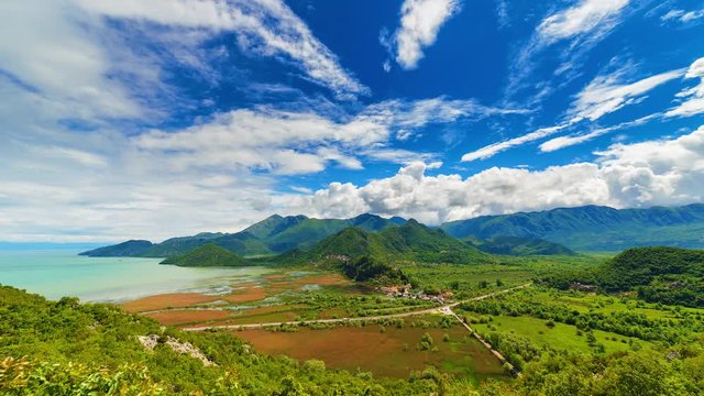 Beautiful landscape of white clouds in blue sky passing by Skadar lake and mountains near Virpazar, Montenegro