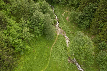 Aerial view of dirt track  crossing mountain creek