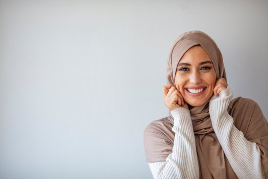 Portrait of beautiful Muslim woman on grey background. Arabian woman with happy smile. Strict formal outfit and elegant appearance. Islamic fashion. Profile of an arab saudi woman