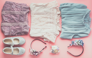 Toned photo of girls' fashion background in pastel colors, lace and tulle dresses, flower headbands, flat lay, top view, selective focus