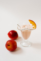 Yogurt with nectarines in a glass, next to fresh organic nectarines. The concept of healthy and delicious food
