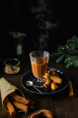 Spanish traditional dessert, churros with hot chocolate sauce on dark wooden table