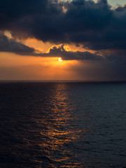 Fototapeta na wymiar The sun between the clouds in the sea