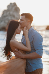 Couple in love at dawn by the sea. Honeymoon trip. Man and woman traveling. Happy couple by the sea...