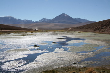 lago del altiplano peruano con cami&oacute;n al fondo