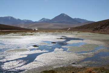 lago del altiplano peruano con camión al fondo