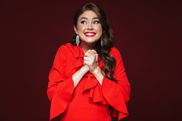 Image of happy woman wearing red dress smiling with looking upward