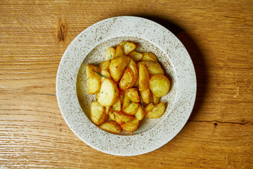 Baked potato (Selyansky) with salt, garlic and onions. Traditional Ukrainian cuisine in white plate. Top view food on wooden baclground.