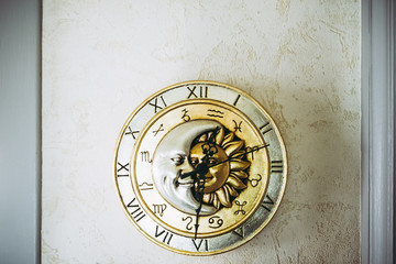 Pendule murale dorée avec soleil et lune