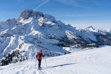 Fototapeta na wymiar active senior woman snowshoeing from Prato Piazzo up to the Monte Specie in the three oeaks Dolomites area near village of Innichen, South Tyrol, Italy