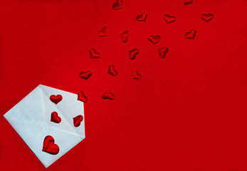 The Concept Of Valentine's Day. Love letter.   Envelope and flying out of it red hearts on a red background.