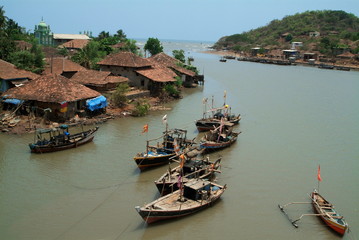 Fototapeta na wymiar Village on river bank in Maharashtra, India. Huts of fishermen seen. 