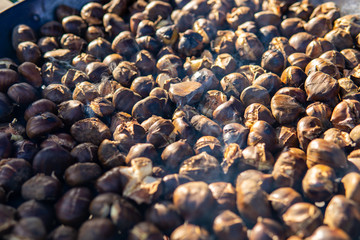 Obraz premium chestnuts roasted on the fire from a street vendor on the road in winter