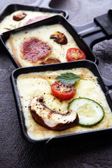 Delicious traditional Swiss melted raclette cheese on diced boiled or baked potato.