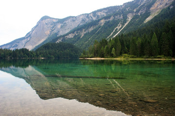 Fototapeta na wymiar Mountains reflected in a green lake