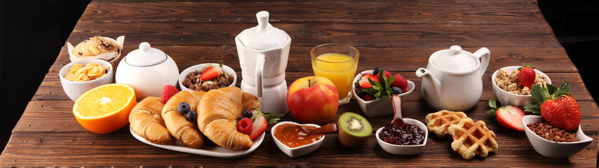 Breakfast served with coffee, orange juice, croissants, cereals and fruits. Balanced diet. Continental breakfast with granola and fruits