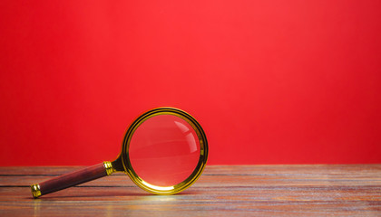 Magnifying glass on a red background. Search and analysis, analytics and study. Pay attention to...