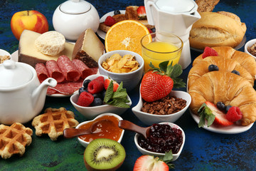 Breakfast served with coffee, orange juice, croissants, cereals and fruits. Balanced diet. Continental breakfast with granola and fruits