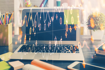 Financial graph colorful drawing and table with computer on background. Multi exposure. Concept of international markets.