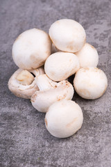 White champignons on a grey structured background