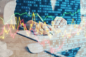 Forex graph on hand taking notes background. Concept of research. Multi exposure