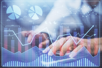 Forex graph with businessman typing on computer in office on background. Concept of analysis. Double exposure.