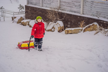 Child having fun on snow tube. Boy is riding a tubing. Winter fun for children