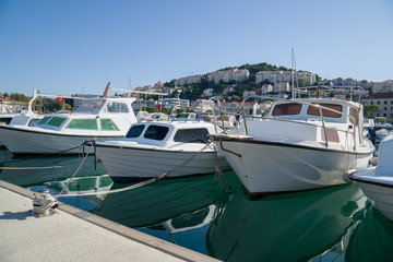 Motorboats lined up along the dockside in a little seaside town